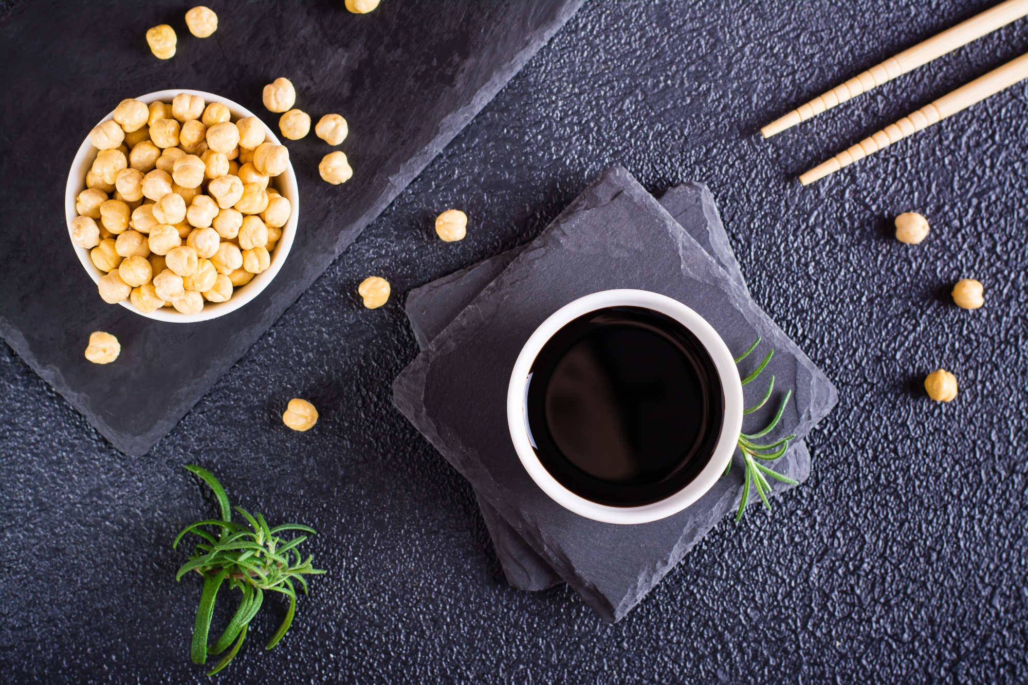 Soy sauce in a bowl and soy beans on the table. Top view
